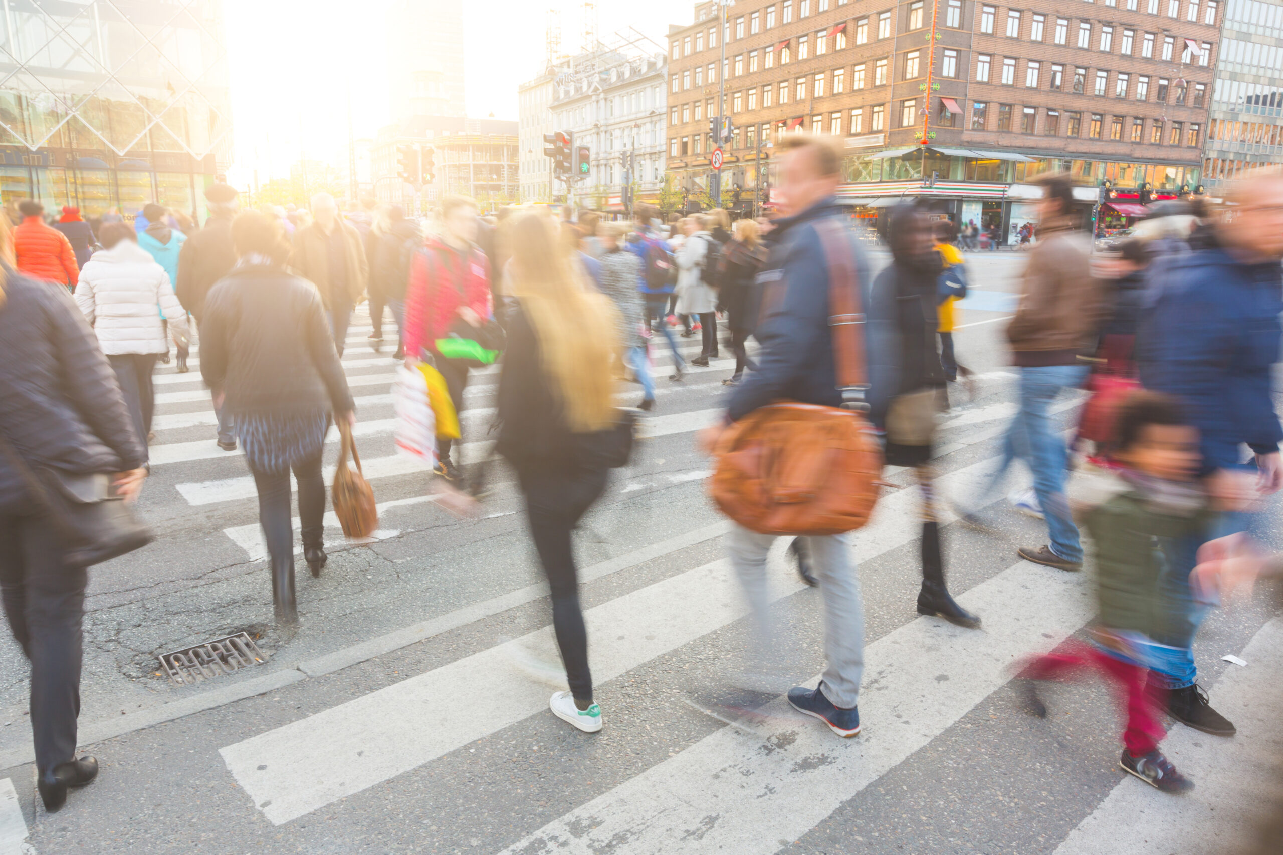 Blurred crowd of people walking on crosswalk in city